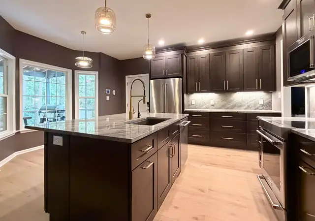 Kitchen remodel with dark shaker cabinets, gray Moreno quartzite counters and bay window dining area