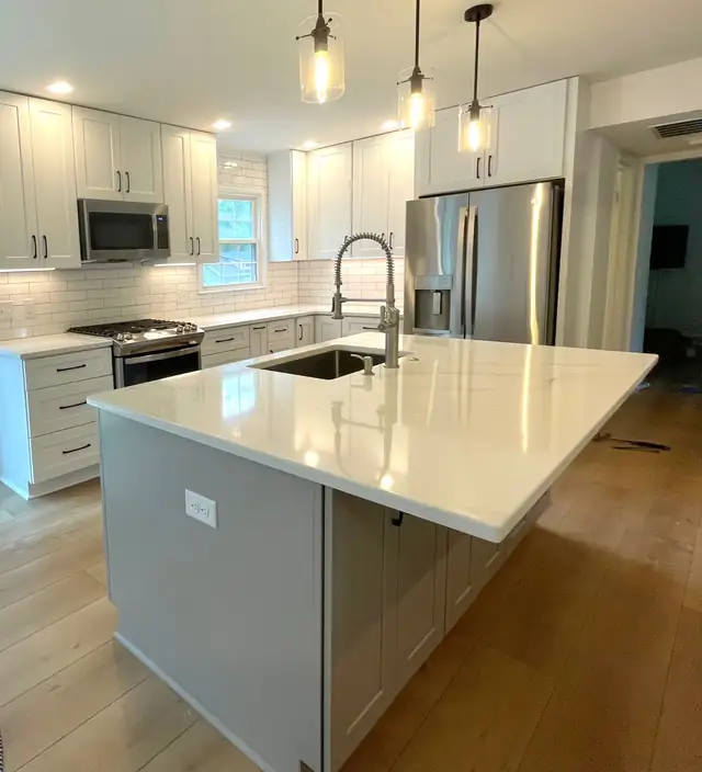 Raleigh, NC kitchen remodel with a separating wall removed, white quartz island, stainless appliances and pendant lights