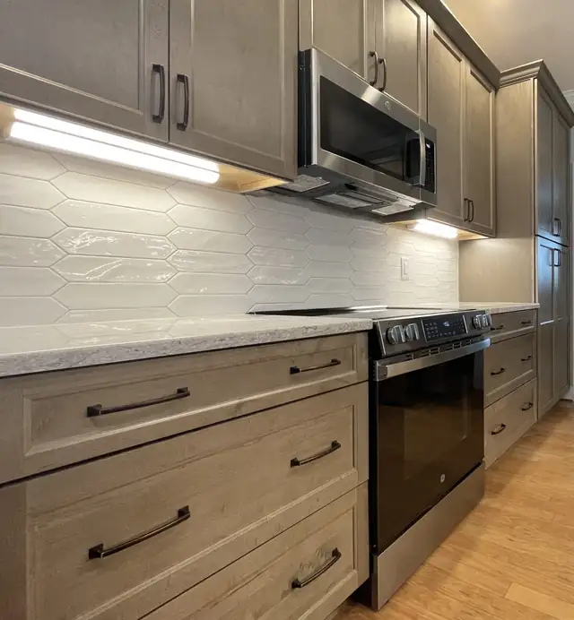 Knightdale, NC kitchen remodel with wood-tone lower cabinets, white picket tile backsplash and stainless range
