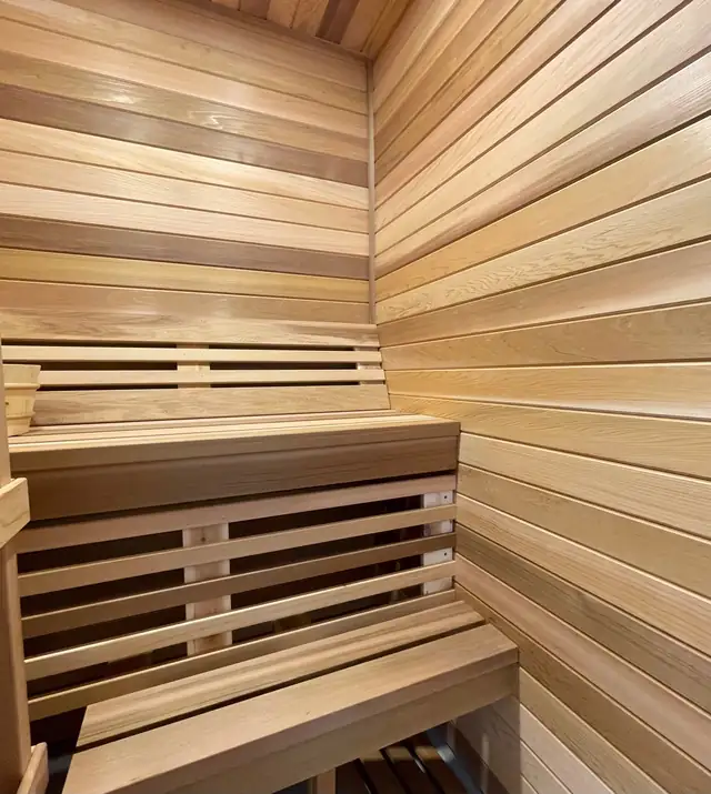 Cedar sauna built into a primary bathroom in place of a garden tub