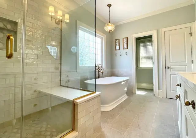 Primary bath remodel in Raleigh, NC with frameless glass shower, freestanding tub and glass block window