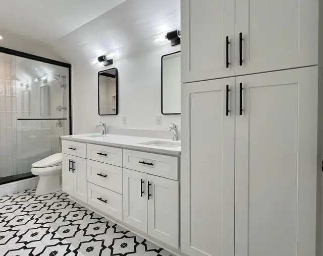 Black and white primary bath remodel in Cary, NC with patterned floor tile, white double vanity and black mirrors